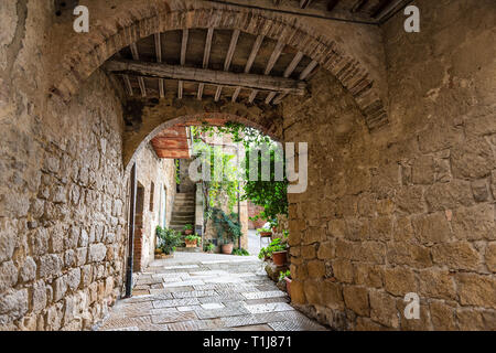 Monticchiello, Italie Val D'Orcia en Toscane avec campagne ruelle de la rue vide de passage étroit tunnel archway dans petite ville village avec personne et vert Banque D'Images