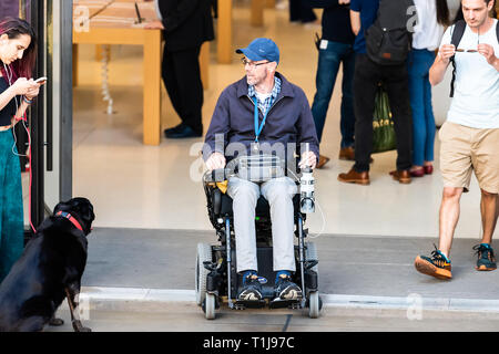 Londres, Royaume-Uni - 22 juin 2018 : les personnes handicapées en fauteuil roulant ou d'un homme assis scooter électrique d'un magasin à l'entrée du bâtiment de fabrication, des personnes qui se Banque D'Images