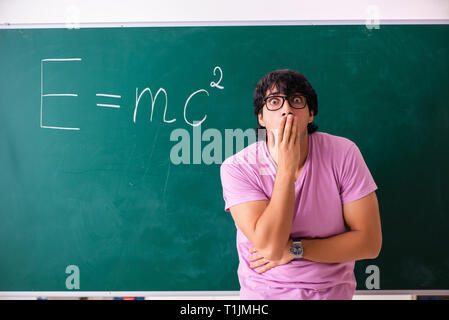 Jeune homme physic debout devant le conseil vert Banque D'Images