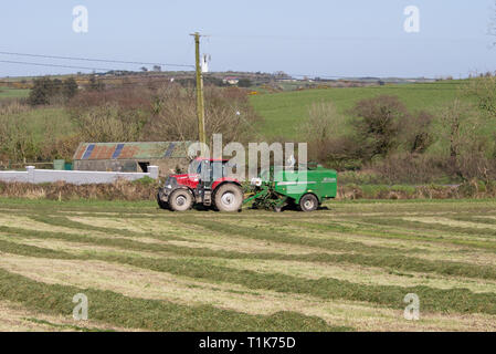 Castlehaven, West Cork, Irlande, le 27 mars 2019. Une autre belle journée de printemps et le beau temps a permis à un agriculteur local pour obtenir son premier de la saison de coupe de l'ensilage en balles et. Credit : aphperspective/Alamy Live News Banque D'Images