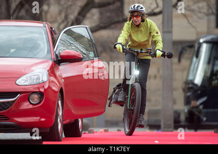 Stuttgart, Allemagne. Mar 27, 2019. Au cours d'une formation à la sécurité pour les conducteurs pedelec, une femme durs passé une voiture qui ouvre la porte. Le ministère des Transports est la promotion de la "e-bike", initiative qui offre formation sûre pour les pilotes pedelec dans tout le pays. L'initiative de la Württembergischer associations cyclistes et Radsportverband Allgemeiner Deutscher Fahrrad-Club Baden-Württemberg est destiné à assurer plus de sécurité dans la circulation. Credit : Marijan Murat/dpa/Alamy Live News Banque D'Images