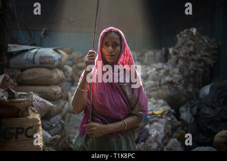 Dhaka, Dhaka, Bangladesh. Mar 27, 2019. Vu une femme à la recherche directement sur la caméra tout en travaillant dans une usine de recyclage en plastique.Les femmes et des travailleur ou le travail des enfants travaillent encore dans de nombreuses usines de recyclage de bouteilles en plastique. La plupart des usines n'entretient pas de bonnes conditions de travail pour l'un de ses ouvriers. Credit : Ziaul Haque Oisharjh SOPA/Images/ZUMA/Alamy Fil Live News Banque D'Images