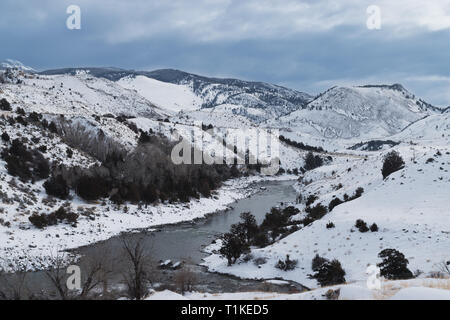 Une rivière qui coule entre les montagnes couvertes de neige dans le Parc National de Yellowstone.​ Banque D'Images