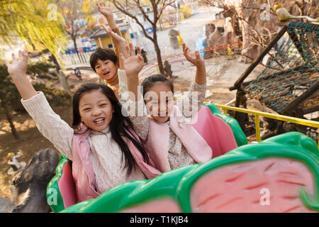 Les garçons et les filles sur un roller coaster Banque D'Images