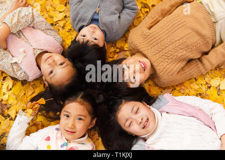 De belles filles et garçons couchés sur le sol Banque D'Images