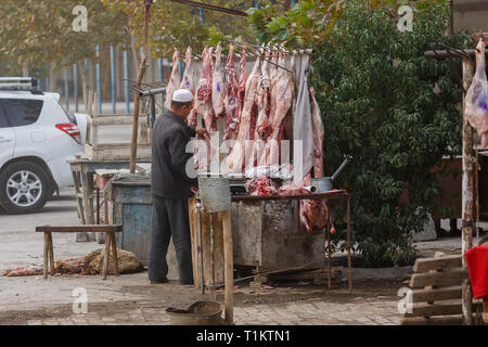 KASHGAR, Xinjiang / CHINE - 1 octobre 2017 : Butcher préparer la viande - Agneau - probablement capté à Kashgar Marché des animaux. Banque D'Images