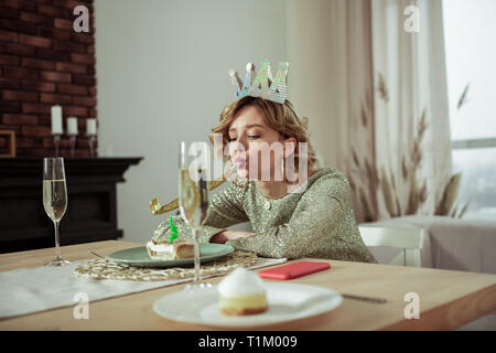 Lonely anniversaire femme assise à la recherche et le morceau de gâteau Banque D'Images