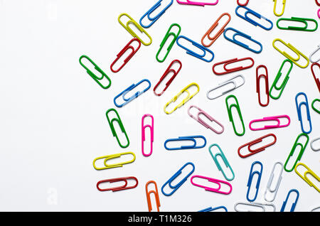 Beaucoup de multi-couleur des clips pour les documents papier à se coucher sur un fond blanc. Close-up Banque D'Images