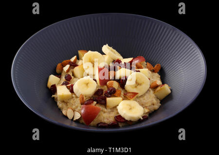 Repas d'avoine bouillie de grains entiers de nourriture dans un bol avec de la pomme, de la banane, canneberges et amandes Banque D'Images