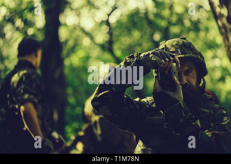 Soldat avec l'appareil photo en forêt Banque D'Images