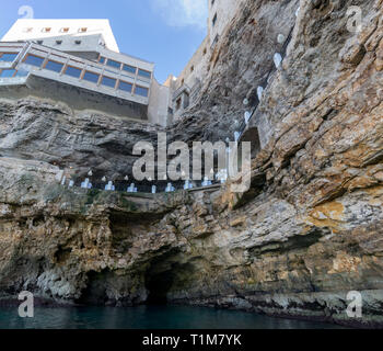 POLIGNANO, ITALIE - 16 août 2016 : le front de mer entrée de Grotta Palazzese, une grotte naturelle en mer maintenant partie d'un restaurant haut de gamme, à Polignano a Mare, Banque D'Images