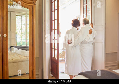 D'âge mûr en peignoirs spa debout à l'hôtel balcony porte Banque D'Images