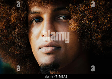 Close up portrait confiant, jeune homme sérieux avec afro Banque D'Images