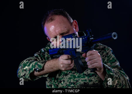 Soldat en treillis de l'armée d'un fusil d'assaut holding Banque D'Images