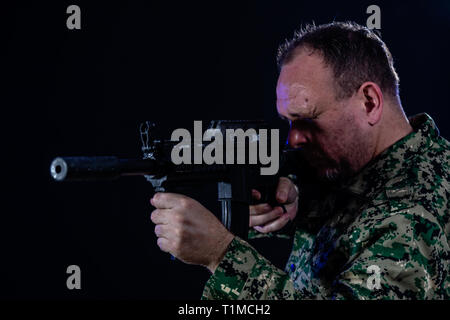 Soldat en treillis de l'armée d'un fusil d'assaut holding Banque D'Images