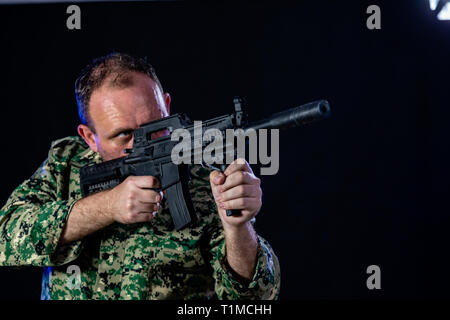 Soldat en treillis de l'armée d'un fusil d'assaut holding Banque D'Images