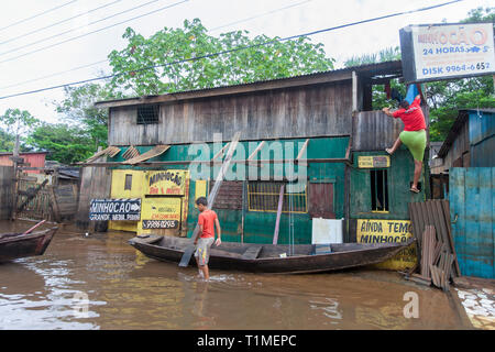 2015 Inondations en Amazonie brésilienne, femme monte sa maison à Taquari, district de la ville de Rio Branco, l'état d'Acre. Les inondations ont touché des milliers de personnes dans l'Etat d'Acre, dans le nord du Brésil, depuis le 23 février 2015, lorsque certaines des rivières de l'état, en particulier l'Acre, la rivière a débordé. De plus fortes précipitations a forcé les niveaux de la rivière plus haut encore, et le 03 mars 2015, le gouvernement fédéral du Brésil a déclaré l'état d'urgence dans l'état d'Acre, où les conditions d'inondations situation a été décrite comme la pire en 132 ans. Une des zones les plus touchées est la capitale de l'état, Rio Branco, où leve Banque D'Images