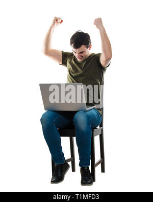 L'homme excité, avec un ordinateur portable sur les genoux, assis sur une chaise les mains en soulevant que des succès à célébrer isolated over white background. Concerné freelancer guy Banque D'Images