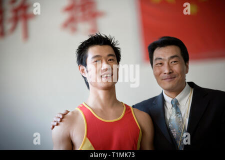 Portrait d'un jeune homme adulte et un mid-adult man hugging dans une salle de sport. Banque D'Images
