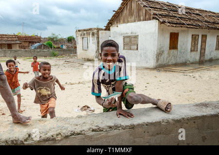 Andavadoaka, Madagascar - Janvier 13th, 2019 : Terroir malgache enfants en train de courir et jouer à côté d'un bâtiment rustique à Andavadoaka, Madagascar. Banque D'Images