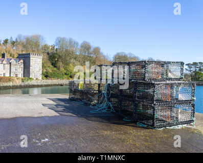 Des casiers à homard sur un quai avec un château en arrière-plan, castletownshend, West Cork, Irlande Banque D'Images