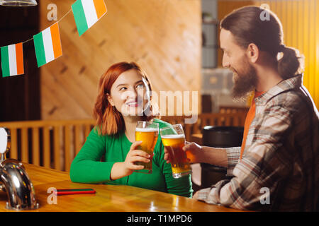 Femme portant chemise verte boire de la bière avec sa nouvelle amie Banque D'Images
