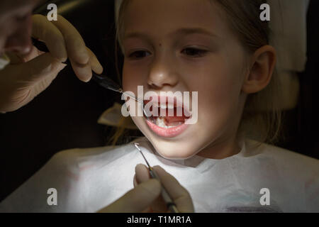 Peur petite fille à l'office, les dentistes dans la douleur lors d'un examen de santé. Les soins dentaires pédiatriques et la peur du dentiste concept. Banque D'Images