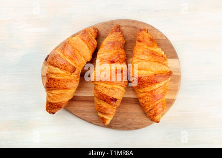 Une photo clé de croissants, tourné à partir de ci-dessus, sur un fond de bois blanc avec une place pour le texte Banque D'Images