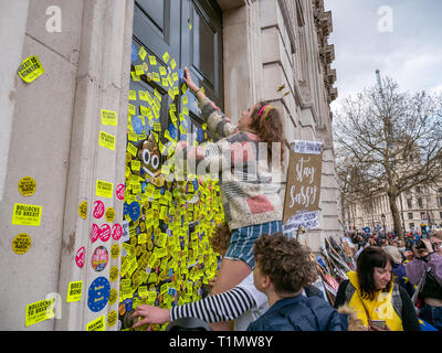 Manifestants anti Brexit mettre des autocollants sur porte de Cabinet au cours de l'immeuble de bureaux de vote du peuple, mars 23 mars 2019, Whitehall, Londres, UK Banque D'Images