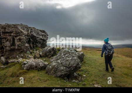 Walker approcher la Pie éperon rocheux près de Conistone dans les vallées du Yorkshire, UK Banque D'Images