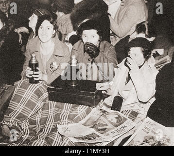 Trois femmes ont une tasse de thé du matin à Piccadilly Circus, Londres, Angleterre en attendant la Procession du couronnement de George VI et la reine Elizabeth en 1936. Du couronnement en images, publié 1937. Banque D'Images