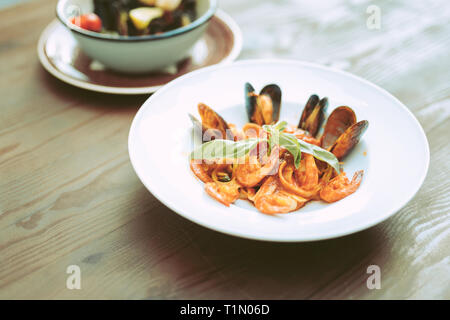 Cher inhabituelle des repas avec des fruits de mer et la sauce debout sur une table en bois Banque D'Images