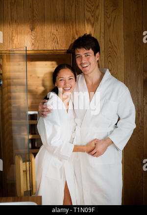 Portrait couple heureux dans des peignoirs pour le spa Banque D'Images