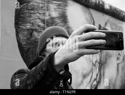 Prendre un touriste en selfies avant du mur de Berlin East Side Gallery Berlin Allemagne Banque D'Images
