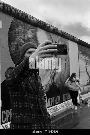 Prend un touriste en selfies avant du mur de Berlin Allemagne Banque D'Images