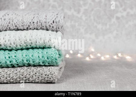 Pulls tricotés élégant de couleur pastel dans différents modèles de tricot pliée en pile sur fond tissu velouté. Hiver et printemps knitwear Banque D'Images