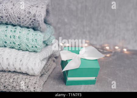 Pulls tricotés élégant de couleur pastel dans différents modèles de tricot pliée en pile avec couleur menthe fort présent avec satin Blanc velouté sur f Banque D'Images