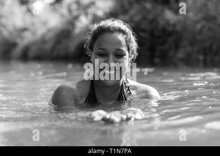 Happy woman swimming in river Banque D'Images