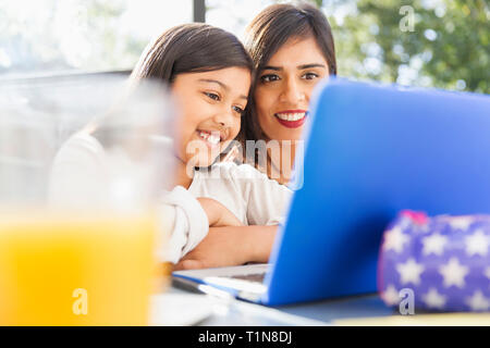 Happy mother and daughter using laptop Banque D'Images