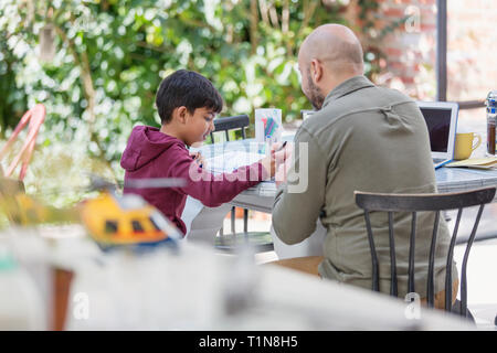 Père et fils à table de coloriage Banque D'Images