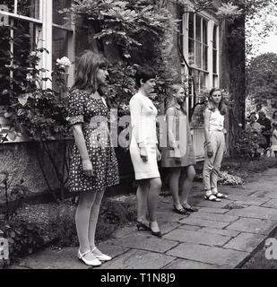 1967, les filles à l'extérieur d'une maison de campagne en modélisant la dernière femme fashions, England, UK. Banque D'Images