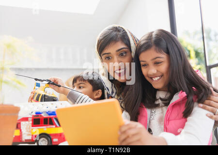 Happy mother and daughter using digital tablet Banque D'Images