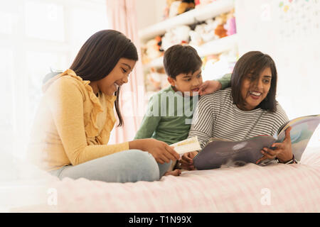 La lecture de livre pour enfants mère on bed Banque D'Images