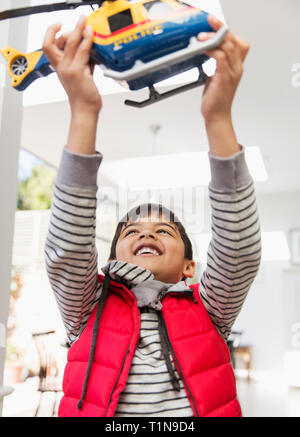 Happy boy playing with toy helicopter Banque D'Images