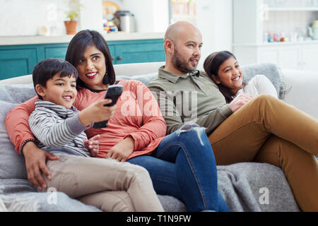 Regarder la télé sur la famille salon canapé Banque D'Images