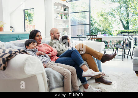 Regarder la télé sur la famille salon canapé Banque D'Images