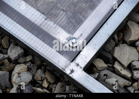 Fixations en polycarbonate avec une armature métallique vis. Les émissions de l'installation, l'installation de serres en polycarbonate. Les émissions pour la maison jardin. Banque D'Images