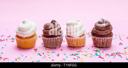 Cupcakes sur fond rose. Quatre cupcakes vanille et chocolat, la bannière Banque D'Images