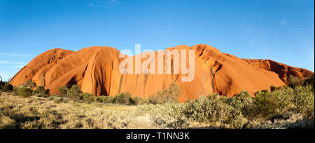 Vue panoramique en soirée d'un côté d'Uluru, depuis l'intérieur du parc national Uluru–Kata tjuta, territoire du Nord, Australie Banque D'Images