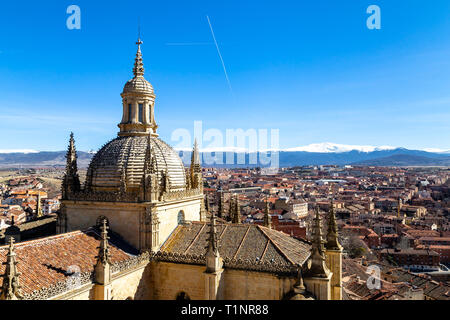 Segovia, Espagne : vue sur le dôme de la cathédrale et de la vieille ville de Ségovie à partir du haut de la tour de cloche en hiver. Les sommets enneigés de Banque D'Images